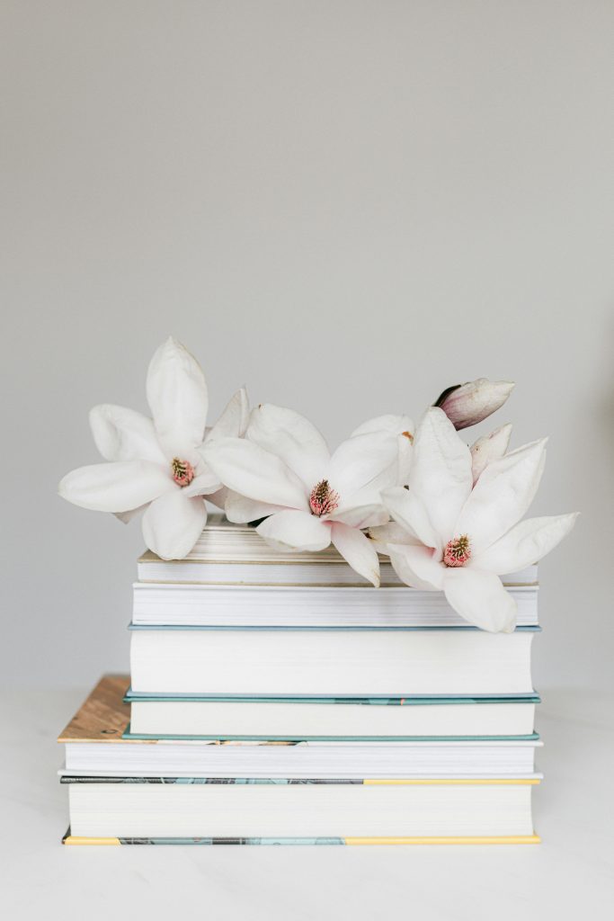 pexels photo 4210789 4210789 Elegant stack of books adorned with white magnolia flowers, creating a serene and minimalist aesthetic.